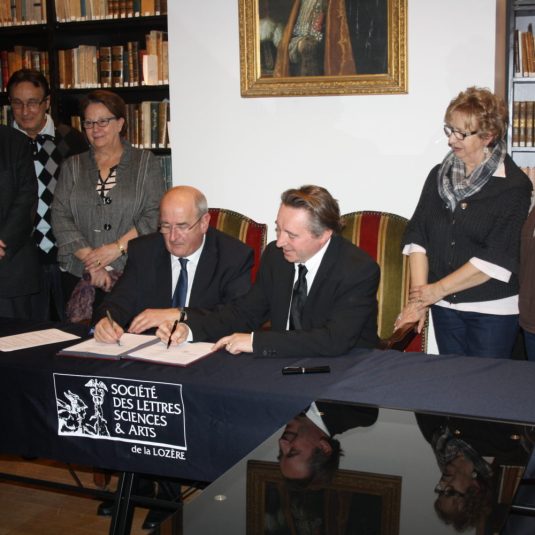 Photo de 2013. Le Maire de Mende Alain Bertrand, signe un partenariat avec M. Chevalier, président de la Société des Lettres.